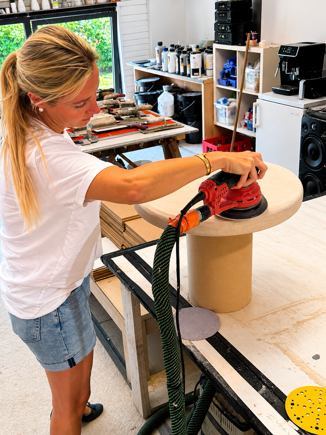 ByMi founder sanding a handcrafted side table in the atelier